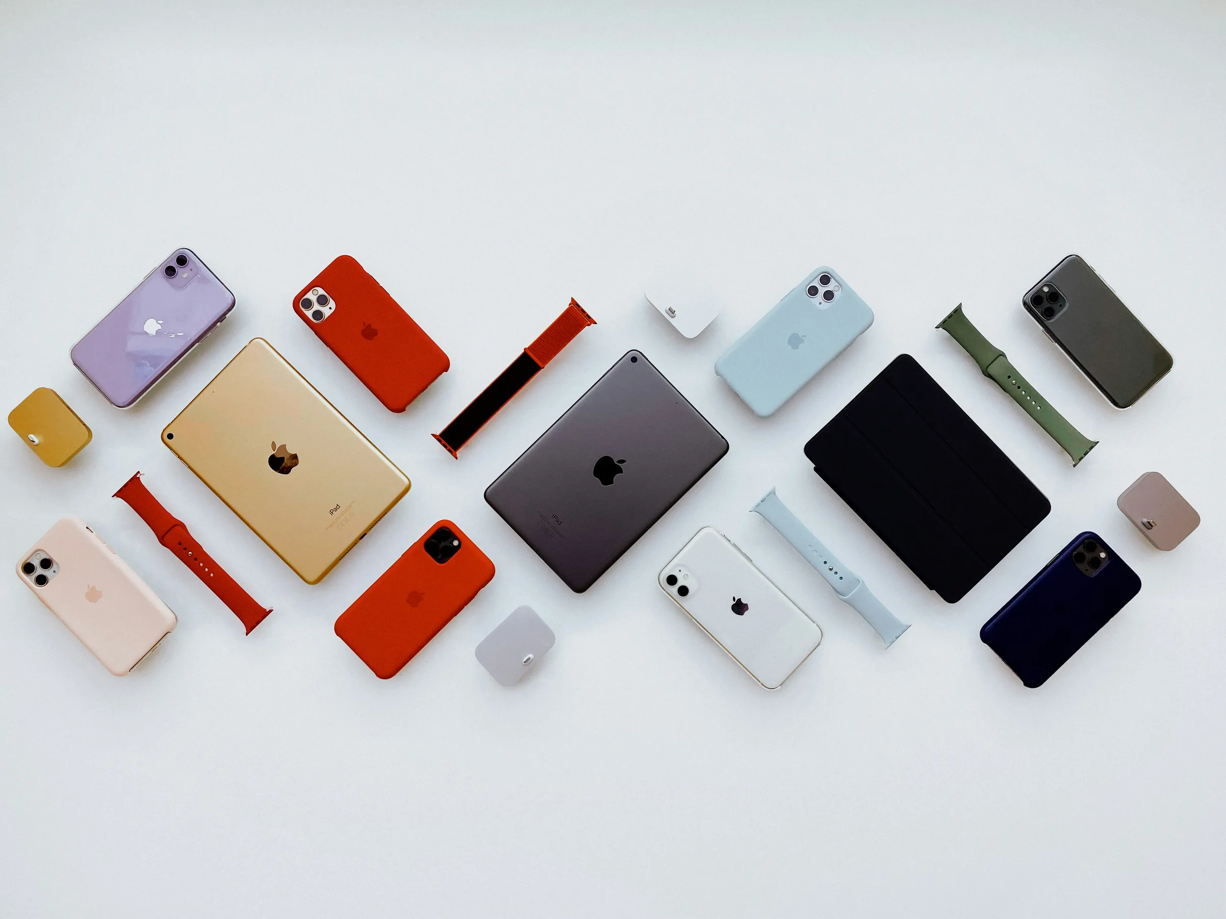 An assortment of iPhones laid out on a light background